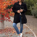 Black button-front coat with notched lapels, long sleeves, and front pockets