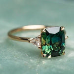 Vintage gold ring featuring dark green cushion-cut center stone and tiny side accents