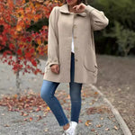 Beige button-front coat with notched lapel, long sleeves, and front pockets