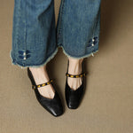 Black leather ballet flats with gold buckled strap and low heel