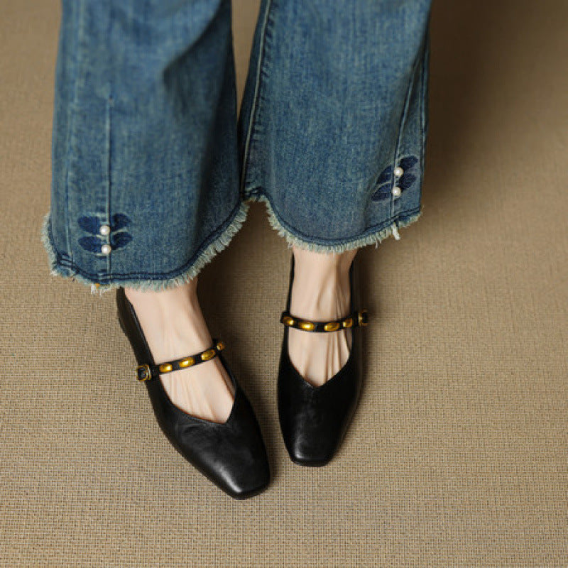 Black leather ballet flats with gold buckled strap and low heel