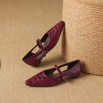 Burgundy Mary Jane flats pair with ankle strap, buckle, laced uppers, pointed toe.