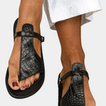 Black T-strap slide sandals with buckled ankle strap, textured upper
