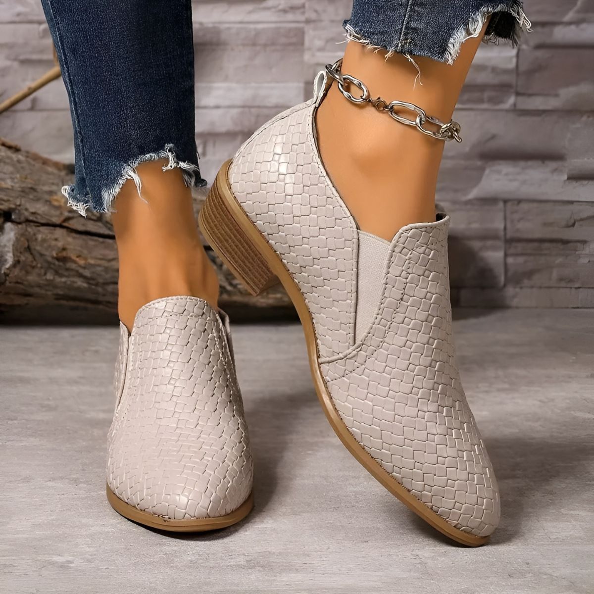 White textured ankle boots with chain strap, low block heel, and pointed toe