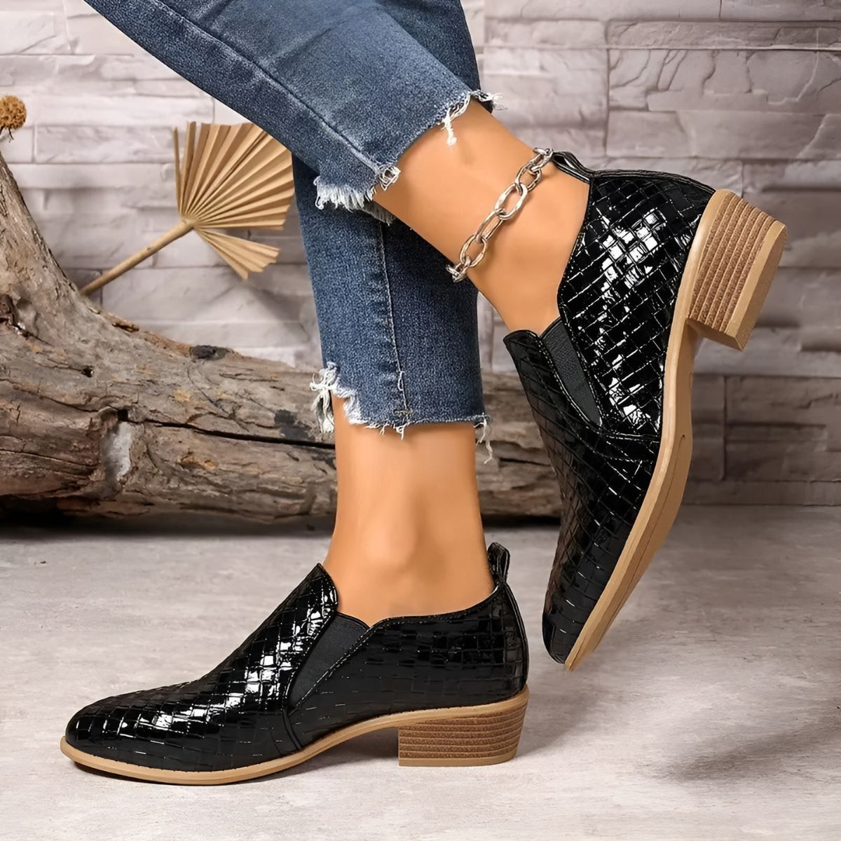 Black textured ankle boots with chain strap, rounded toe, and block heel