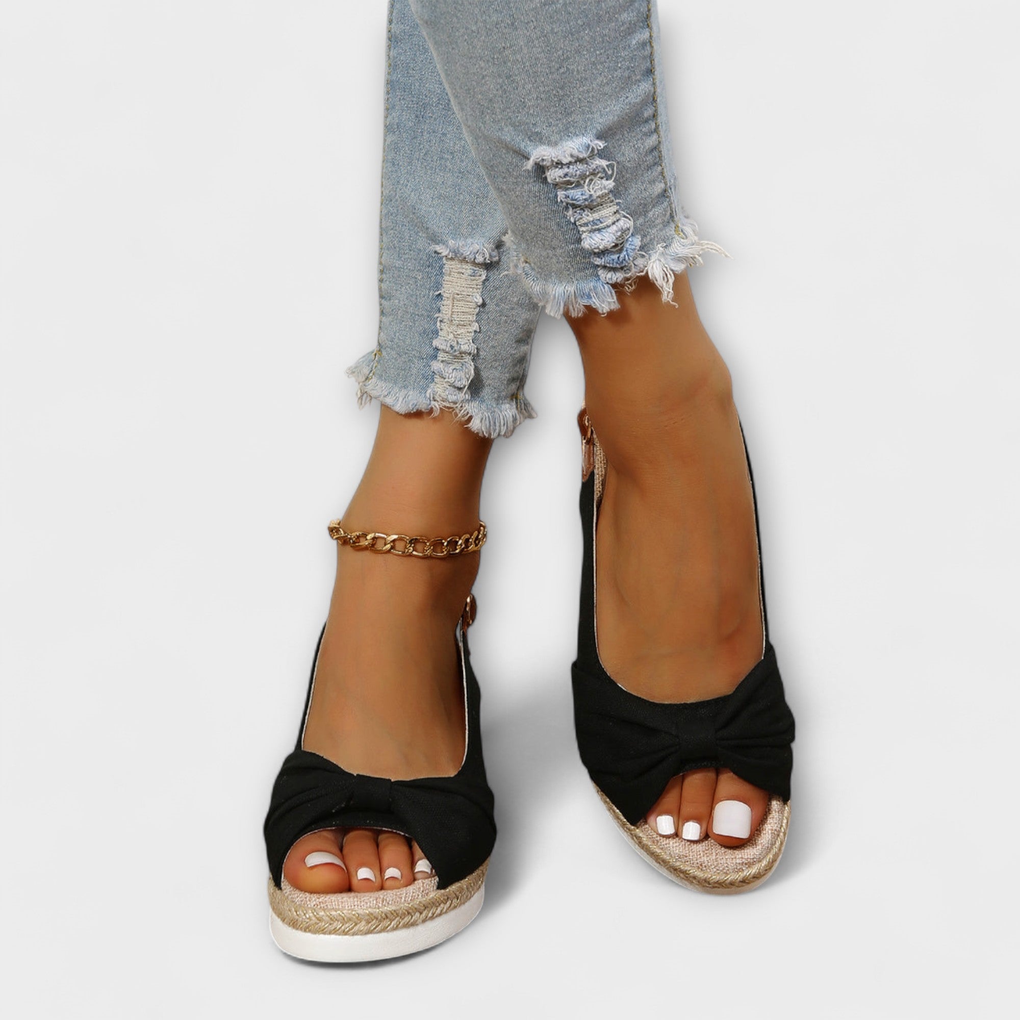 Black espadrille platform sandals with toe bow and ankle chain strap