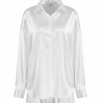 White button-front pajama blouse with pointed collar, long sleeves, relaxed ruffle hem