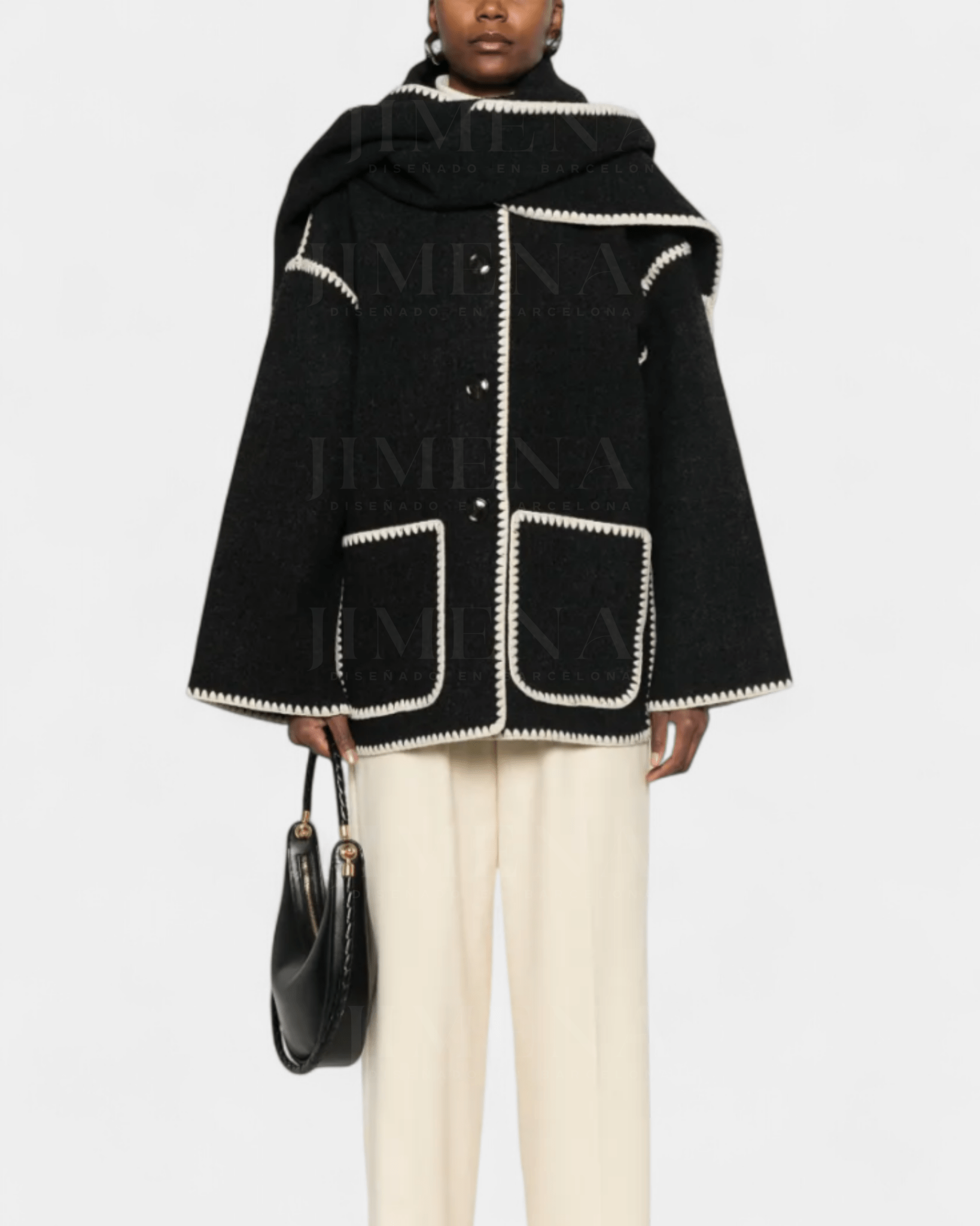 Black wool poncho-style coat with integrated scarf, white trim, flap pockets and fringe