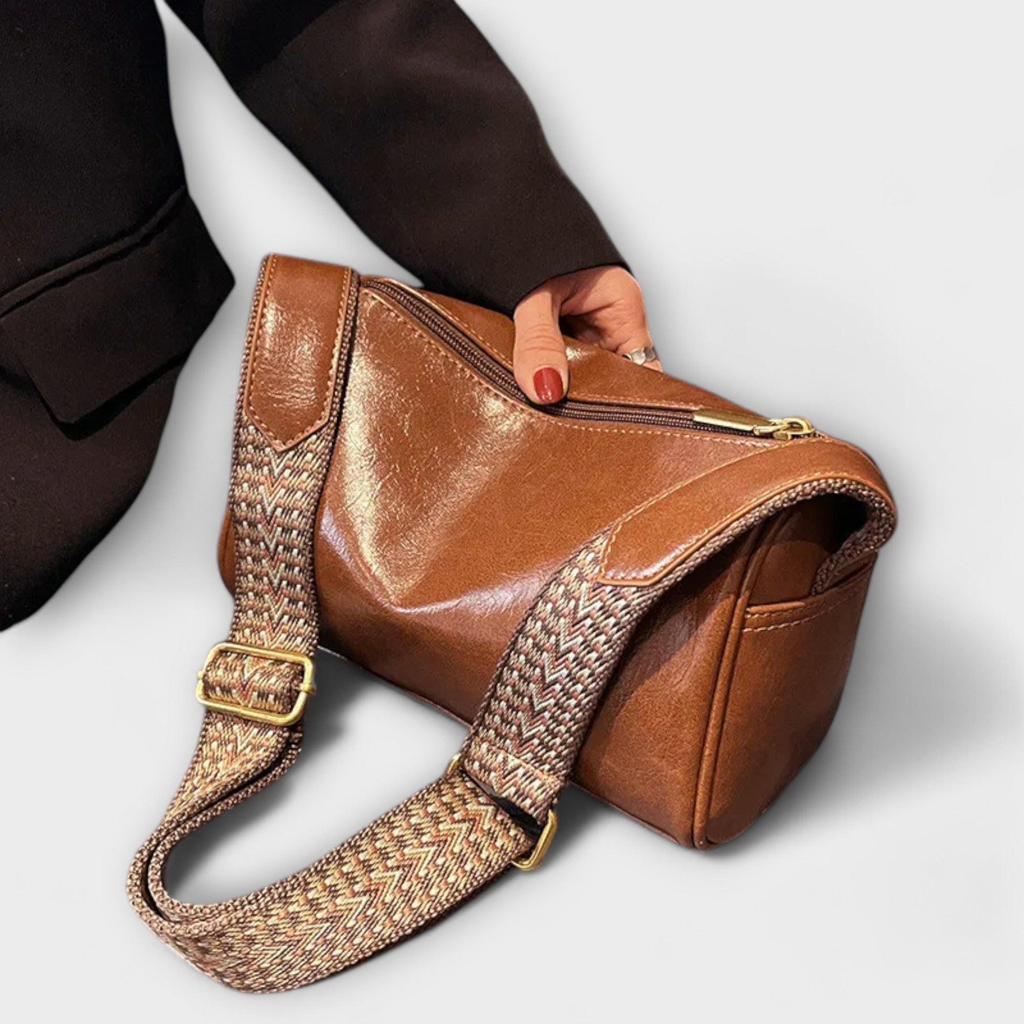 Tan retro crossbody bag with woven strap and gold-tone buckle, small structured shape.