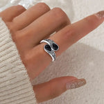 Silver-tone ring with two dark oval stones, ornate filigree sides, flower engravings