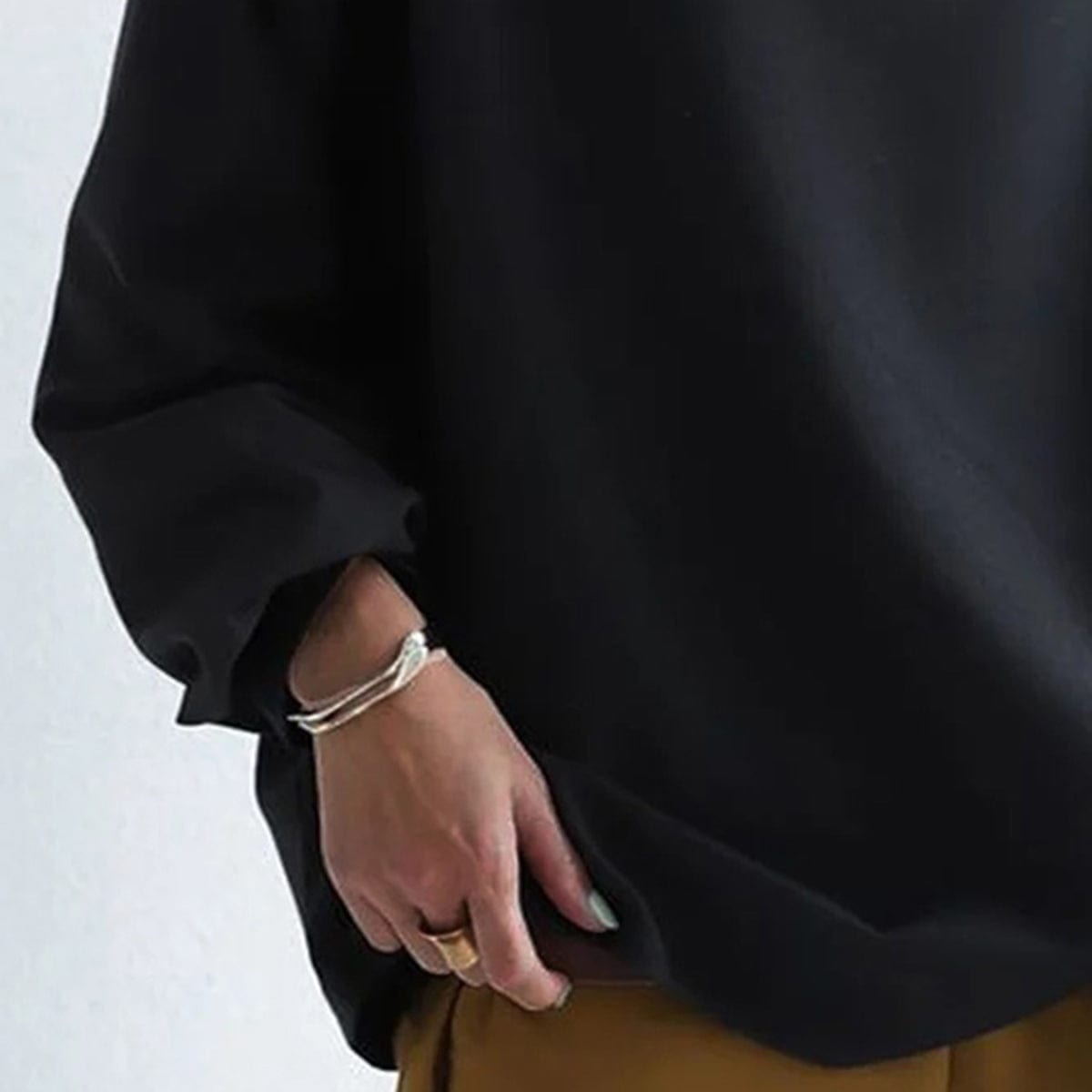 Black high-neck pullover sweater sleeve and hem close-up