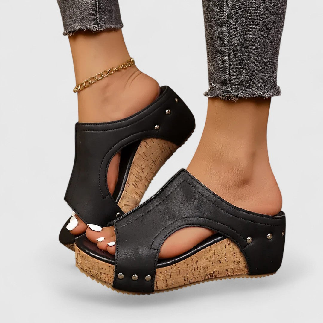 Black platform orthopedic wedge sandals with studded straps and cork-style footbed