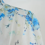 Close-up of blue floral print on white fabric with lightweight texture