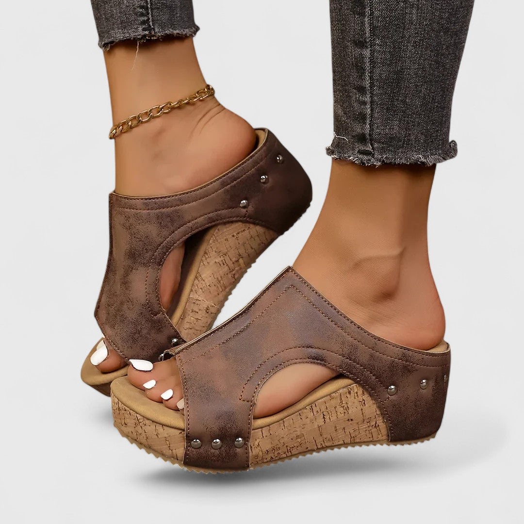 Dark brown platform orthopedic wedge sandals with studded straps and cork-style insole