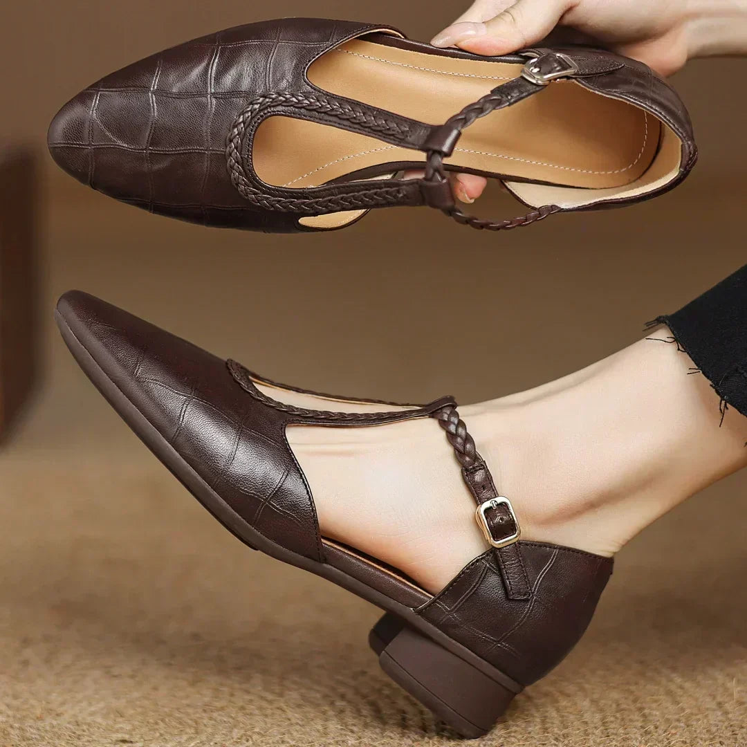 Brown leather pointed-toe flats with braided strap and gold buckle
