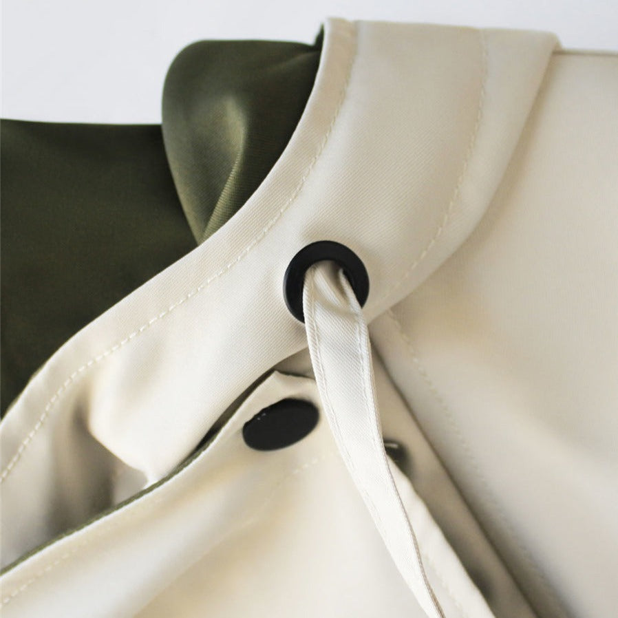 Snap closure detail on two-tone parka jacket, black button on cream trim