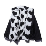 Reversible winter jacket showing black outer shell with white heart-fleece inner side