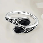 Silver-tone ring with two dark oval stones and engraved flower details