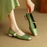 Green Mary Jane ballet flats with ankle strap, bow detail, and low block heel.