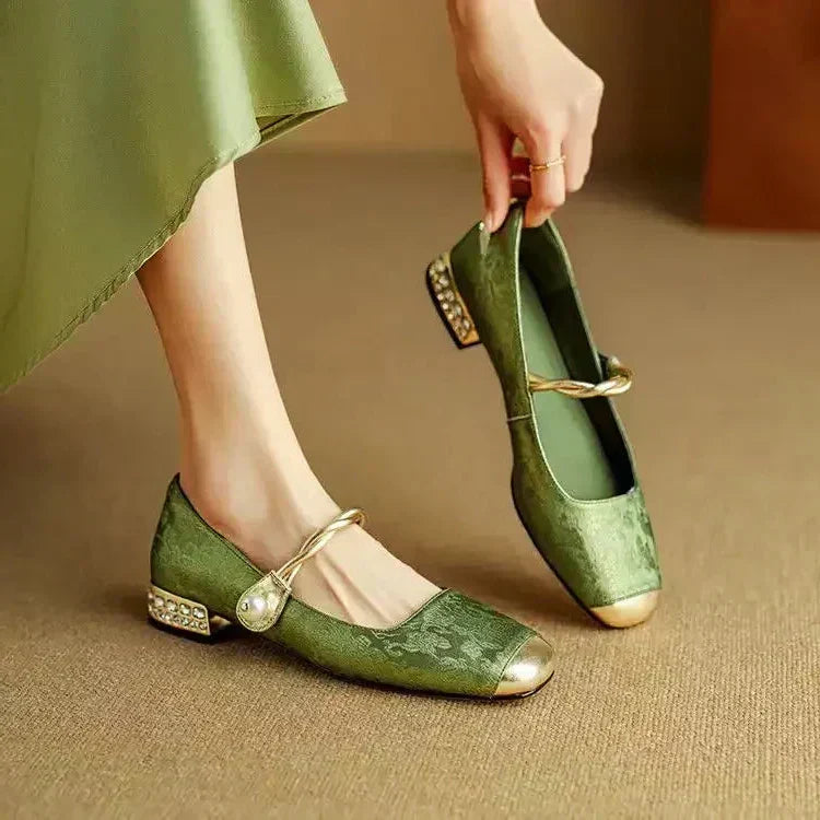 Green Mary Jane ballet flats with ankle strap, bow detail, and low block heel.