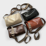 Assorted retro crossbody bags in beige, black, and brown with woven straps and zips.