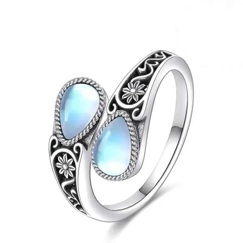 Silver-tone ring with two teardrop moonstone-like ovals and etched leaf flower design