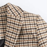 Plaid coat fabric close-up in beige, black, and brown houndstooth pattern