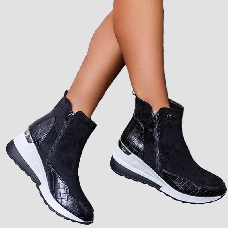 Orthopedic ankle boots in dark suede, side zipper, white cushioned sole.