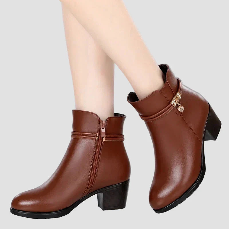 Brown ankle boots on model with faux fur cuff, decorative strap, and block heel