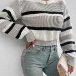 Oversized knit sweater in off-white with wide black horizontal stripe and ribbed cuffs