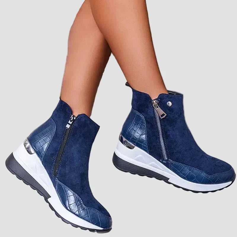 Orthopedic ankle boots in blue suede, side zipper, cushioned white sole.