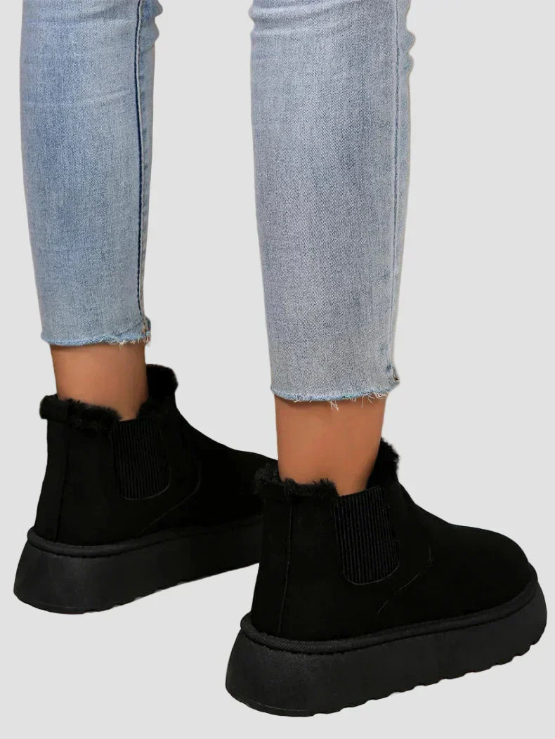 Black ankle boots with elastic side panels and rounded thick rubber sole
