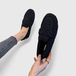 Black warm slip-on slippers with fuzzy lining and moccasin-style seam detail