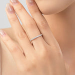 Slim silver pavé eternity ring worn on a hand