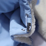 Close-up of light blue jacket hardware and fleece-lined edge