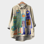 Light beige long-sleeve button-up blouse with colorful character print and collared neckline