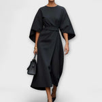 Black satin midi dress with wide batwing sleeves and waist belt, crossover drape.