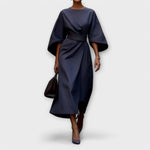 Navy satin midi dress with wide batwing sleeves and waist tie, wrap-style drape.