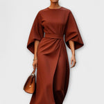 Rust brown satin midi dress with wide batwing sleeves and waist belt, gathered front.