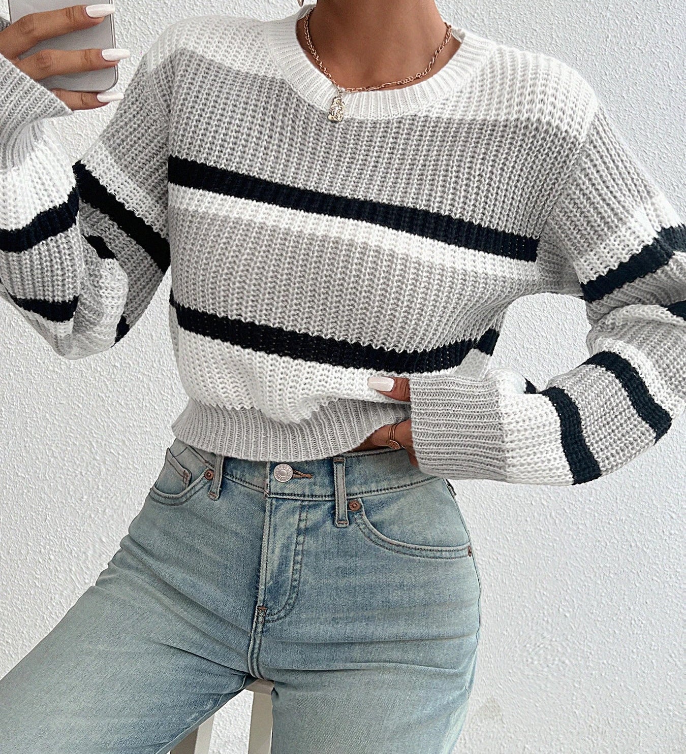 Oversized knit sweater in off-white with black horizontal stripe across chest and sleeves