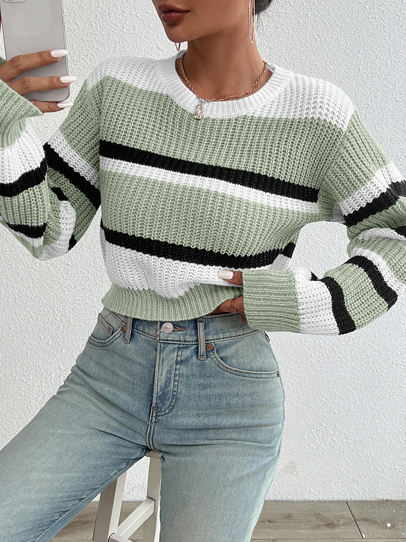 Oversized knit sweater in green and off-white with black horizontal stripe and ribbed hem
