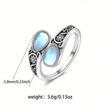 Silver-tone ring with two oval light-blue moonstone accents and carved flower motif