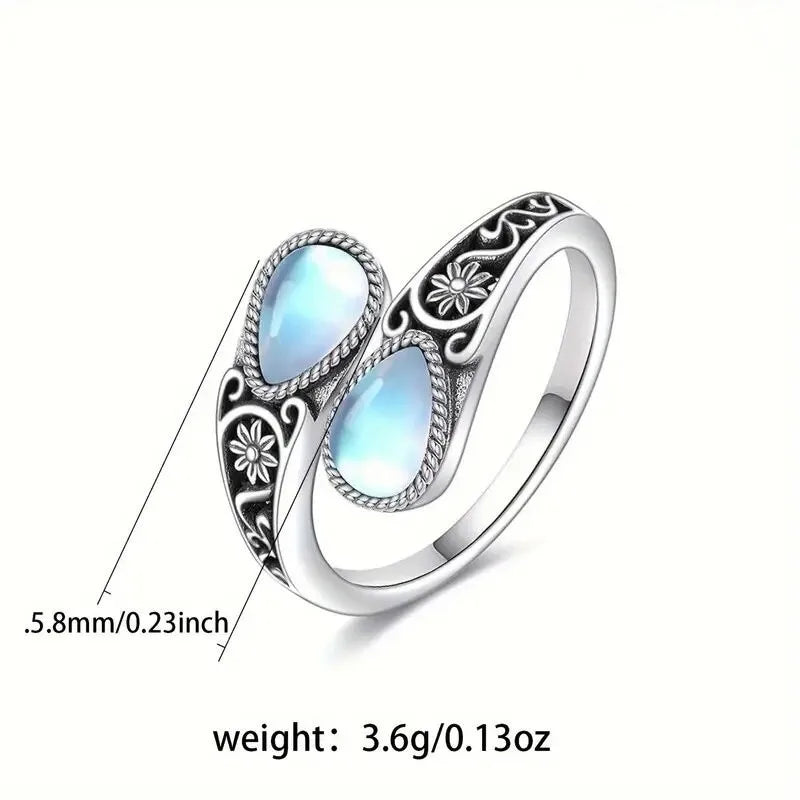 Silver-tone ring with two oval light-blue moonstone accents and carved flower motif