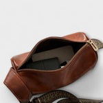 Rust brown crossbody bag open view with zip top and woven adjustable strap.