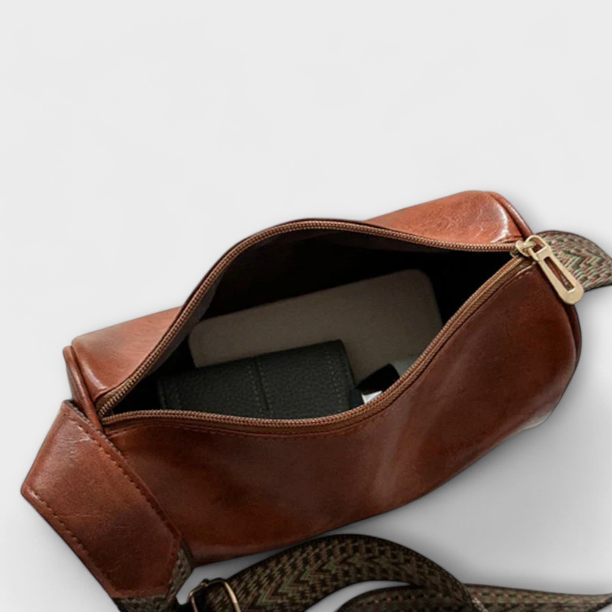Rust brown crossbody bag open view with zip top and woven adjustable strap.