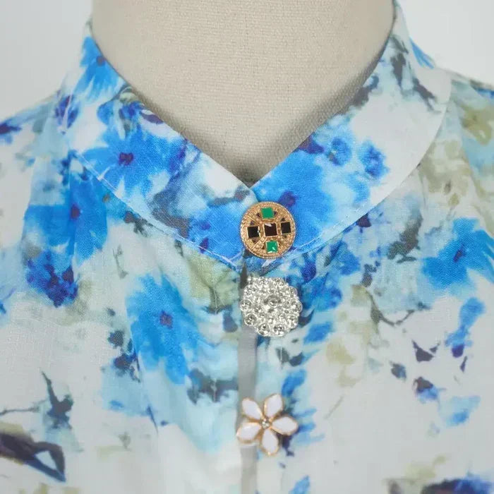 High collar with blue floral print and decorative gold button with crystal charm