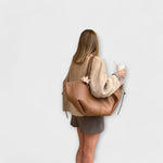 Brown leather-look hobo tote bag with U-shaped front and tied side straps