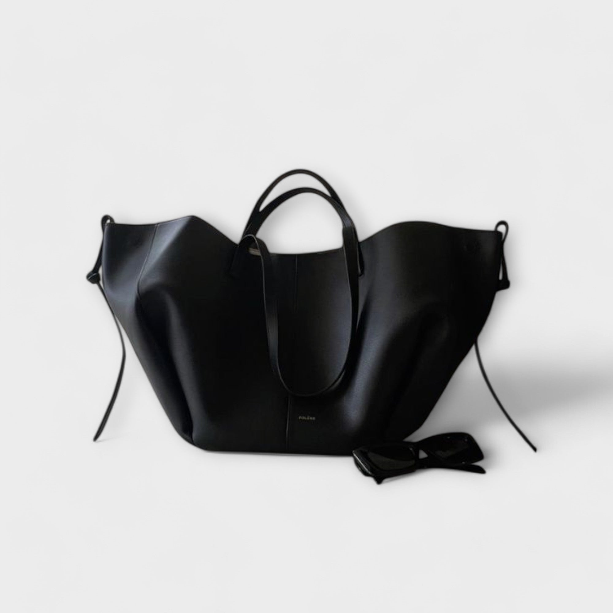 Black leather-look hobo tote bag with curved handles and side tie straps