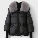 Black puffer jacket with faux fur collar, zip front, flap pockets.