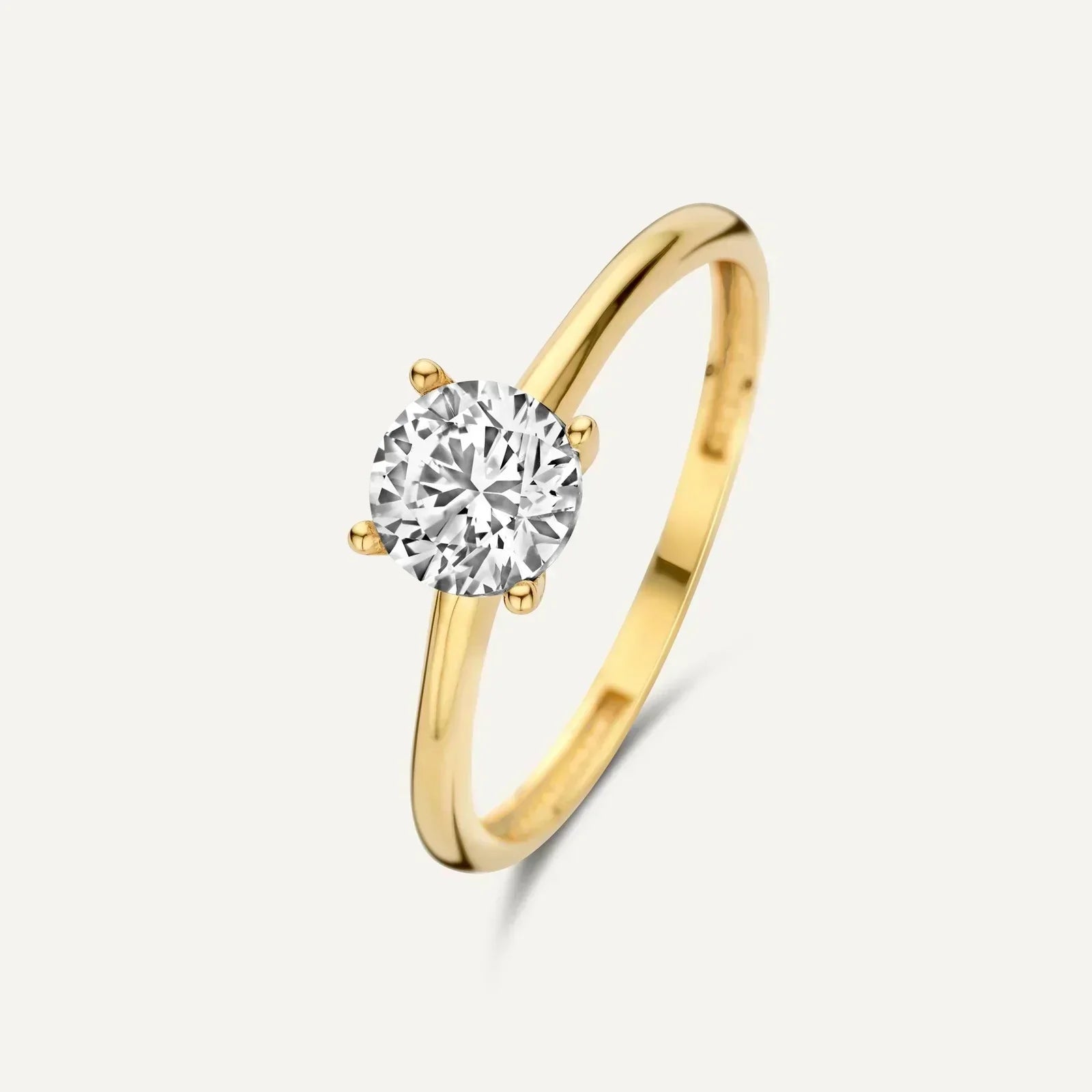 Gold ring with round clear gemstone solitaire held by four prongs